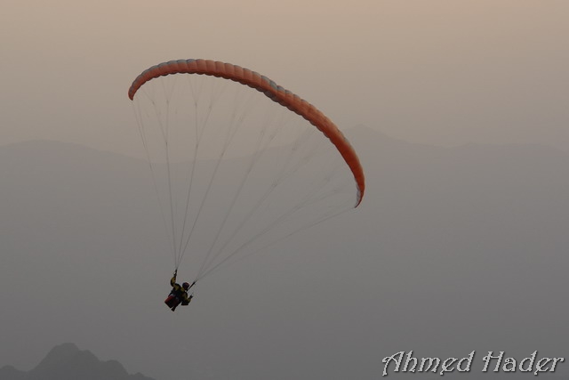 adventure parachuting over mountain near clouds